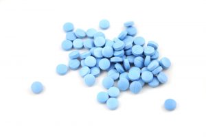 Bright,Blue,Pills,Closeup,On,White,Background